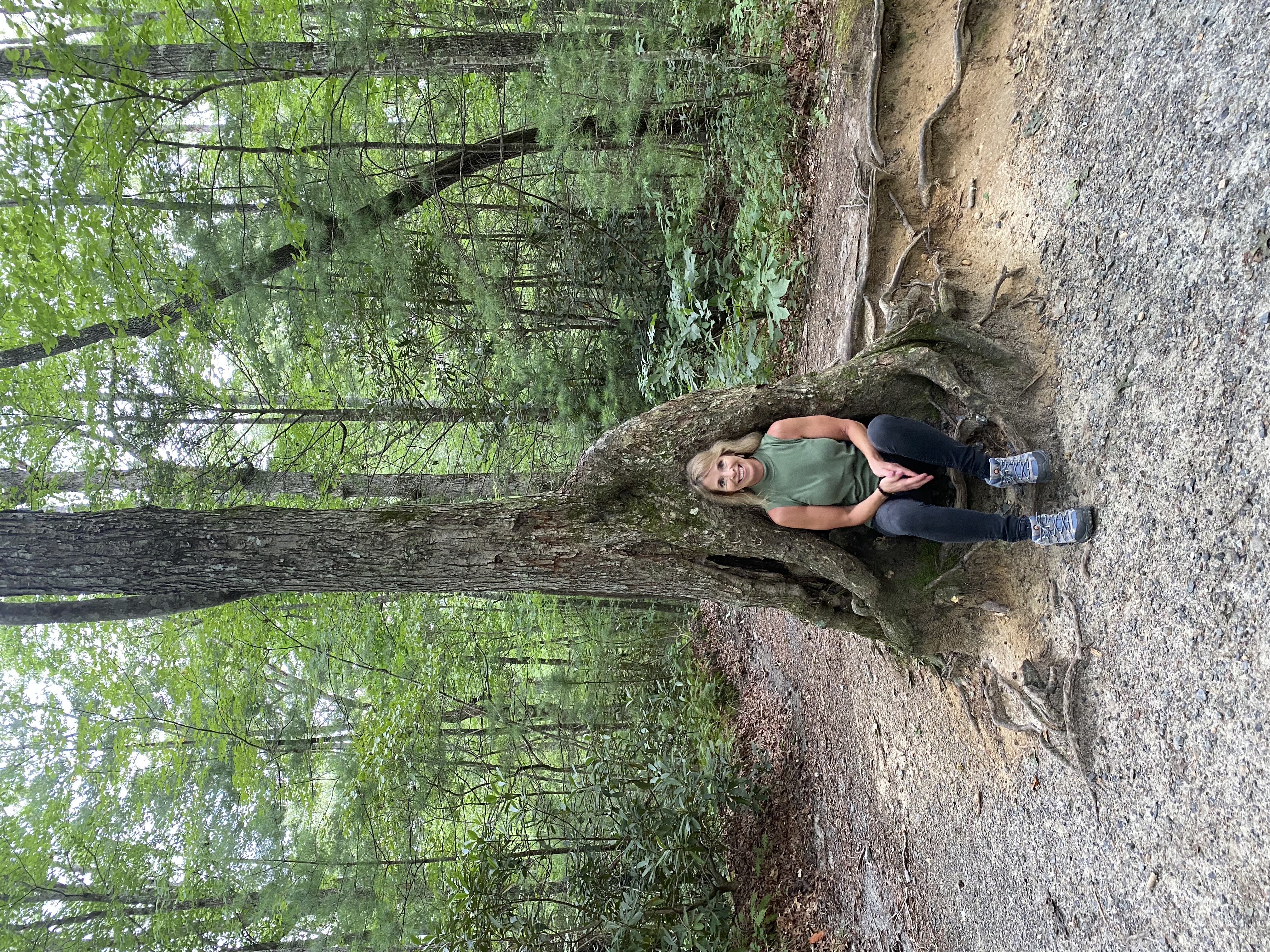 Instructor sitting by tree roots